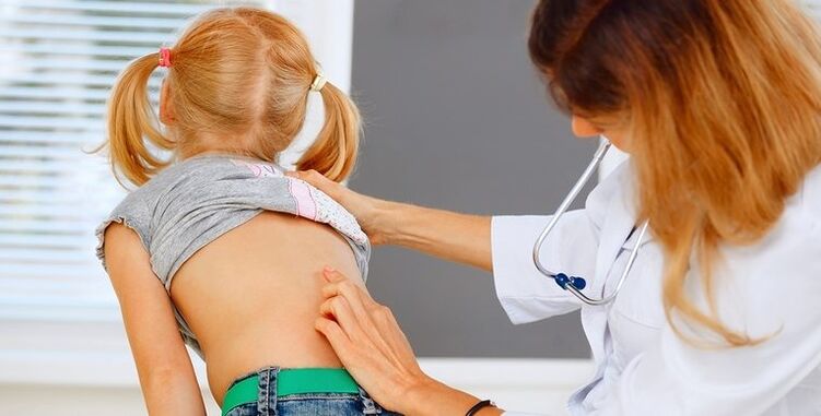 Doctor examines a child's back with back pain